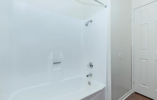 a white tub sitting next to a shower