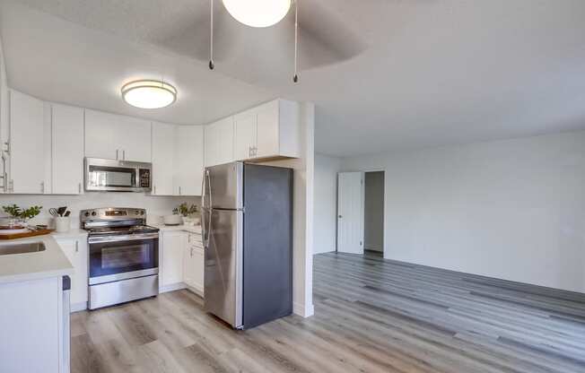 a kitchen with white cabinets and stainless steel appliances