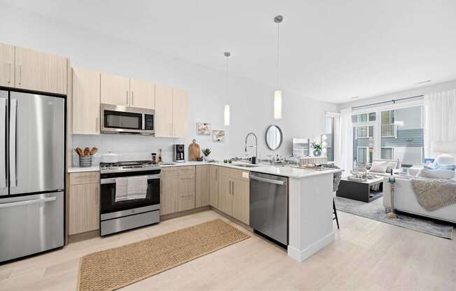 A modern kitchen with a refrigerator, oven, and microwave.