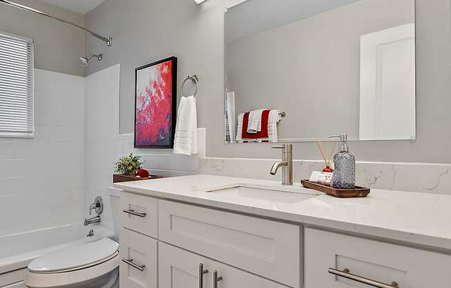 a bathroom with white cabinets and a toilet and a sink