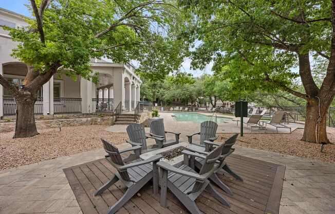 A patio with chairs and a table in front of a house.