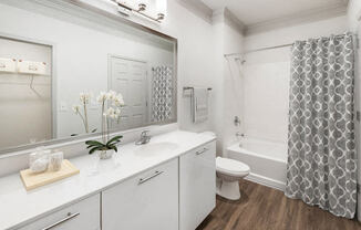 a white bathroom with a shower and a sink and a toilet