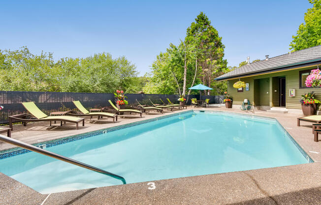 Lake Oswego Apartments for Rent - Westlake Meadows - Sparkling Outdoor Pool With Crystal Clear Water, Comfortable Lounge Chairs, and Additional Seating With Umbrella Covering