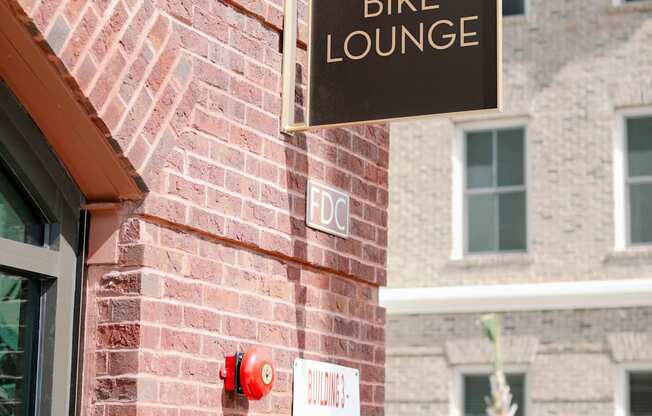 a bike lounge sign on the side of a brick building at The Merchant Apartments, South Carolina 29403