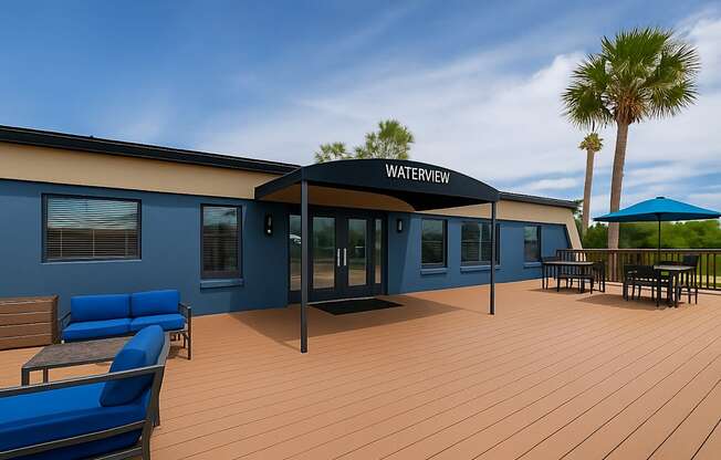 A building with a sign that says Waterview sits on a patio with blue chairs and a table.