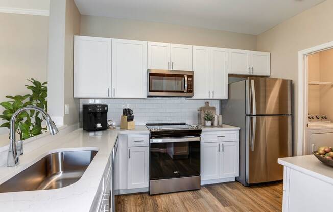 a kitchen with white cabinets and stainless steel appliances