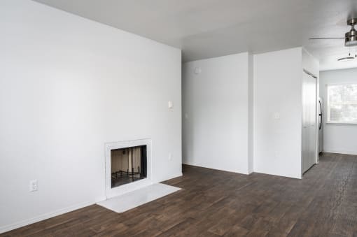 an empty living room with white walls and a fireplace