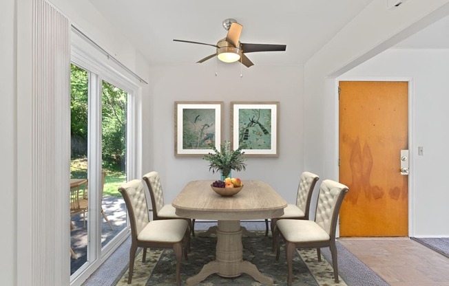 a dining room with a table and chairs and a ceiling fan