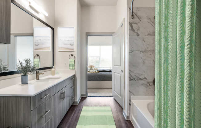 A bathroom with a green shower curtain and a white sink.