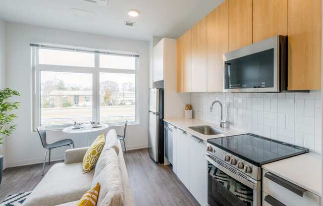 a living room with a couch and a kitchen with a sink