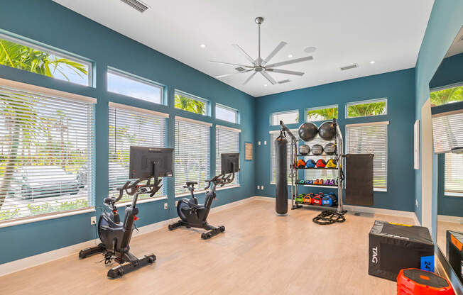 the gym has plenty of exercise equipment and windows