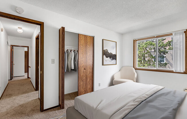 A bedroom with a bed, chair, and wardrobe.
