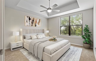 a bedroom with a large window and a ceiling fan