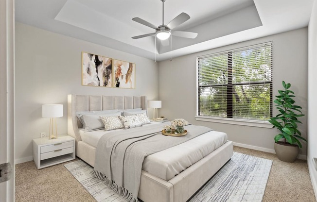 a bedroom with a large window and a ceiling fan