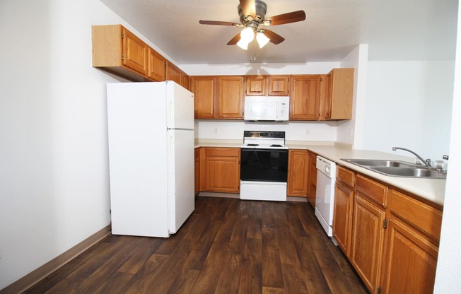 a kitchen with a white refrigerator freezer next to a stove top oven