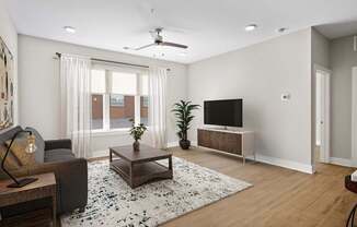 A living room with a couch, a coffee table, and a television.