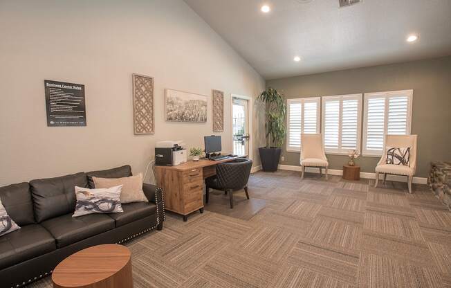 A business center with a black couch, a wooden coffee table, and a carpet on the floor at Zinfandel Village Apartments, California, 95670