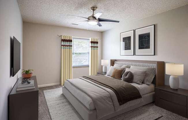 A bedroom with a large bed, a ceiling fan, and two lamps.