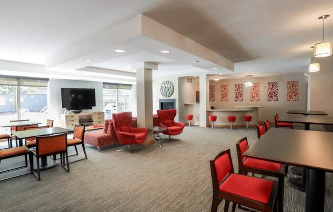 A room with red chairs and a television.