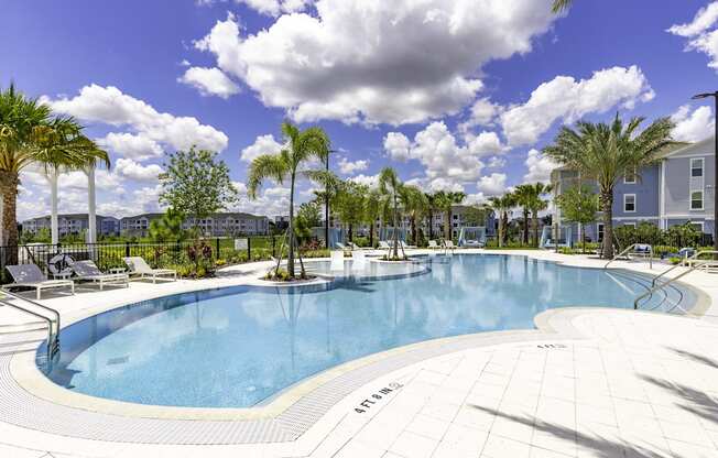A large outdoor swimming pool surrounded by palm trees.