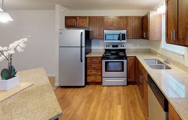 A kitchen with a refrigerator, microwave, and stove.at Cypress Court, St Cloud Minnesota