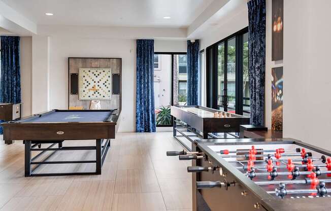 A foosball table is in a room with a pool table.