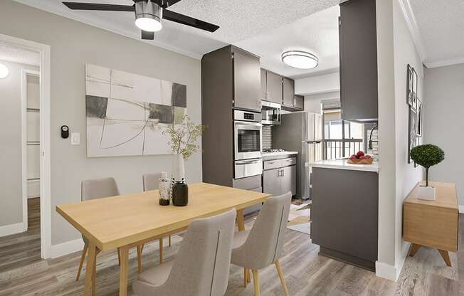 Hardwood floored dining room with view of modern-styled kitchen.