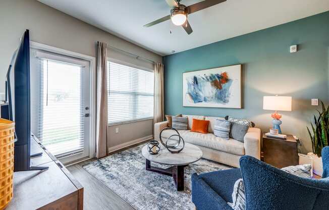 a living room with a couch and a ceiling fan