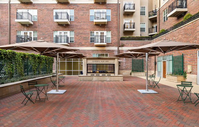 A patio with tables and chairs and a fireplace.