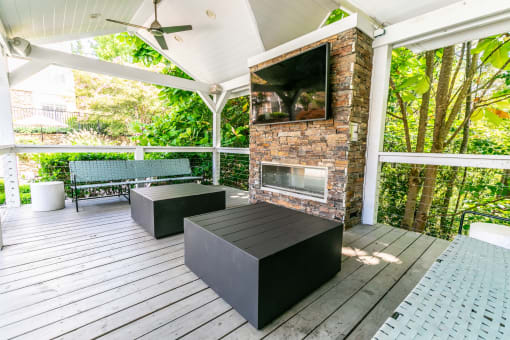 the screened in porch has a fireplace and a bench