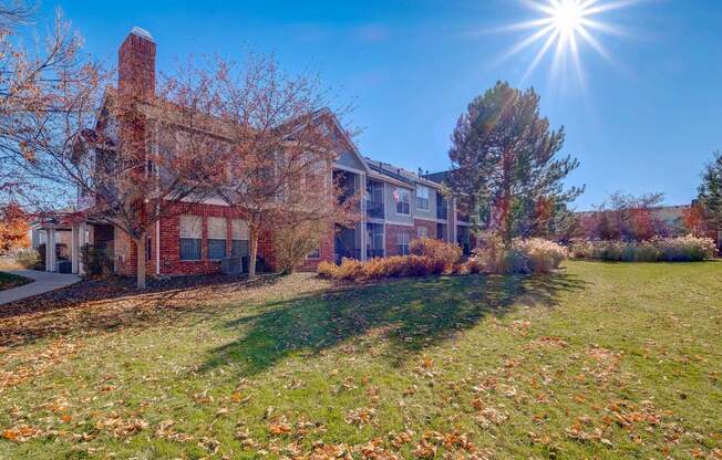 a large brick house with the sun shining in front of it