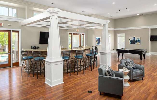 A large white pillar in a spacious room with a pool table.