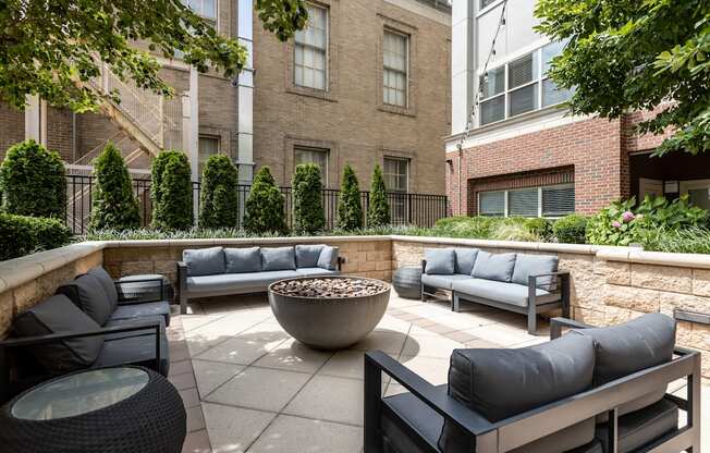 A patio with black furniture and a fire pit.