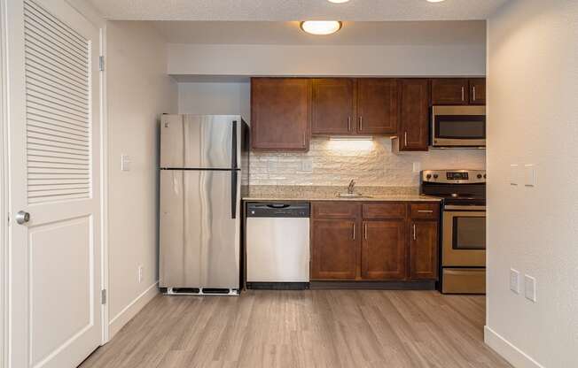 a kitchen with wooden cabinets and stainless steel appliances