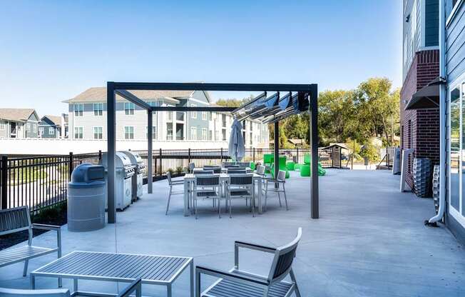 A patio with a table and chairs under a roof.