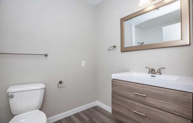 a bathroom with a toilet sink and mirror