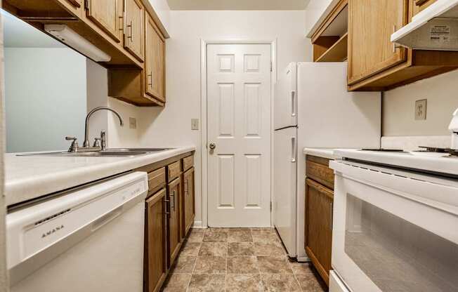 A kitchen with white appliances and wooden cabinets
