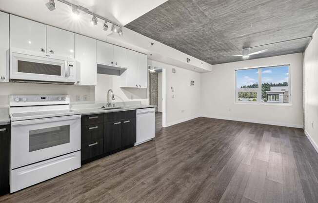 A kitchen with white appliances and wooden floors.
