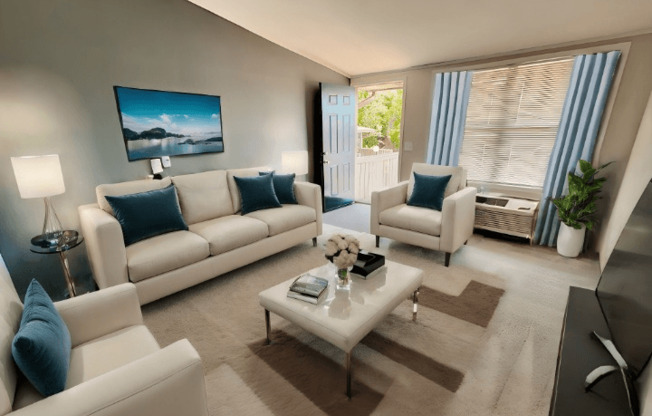 A living room with a white sofa, a white armchair, and a coffee table.
