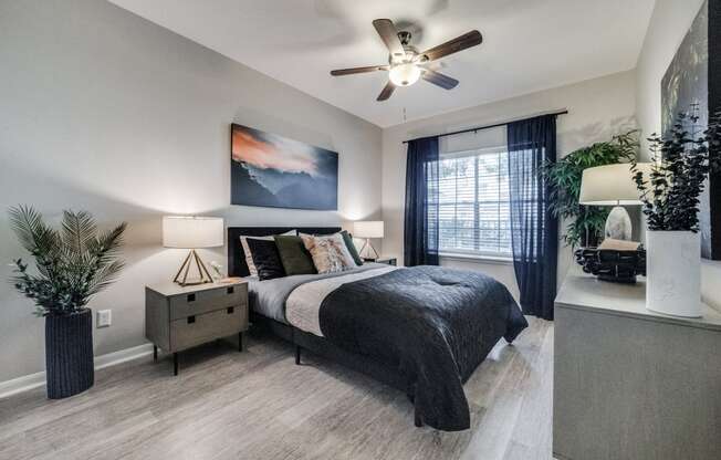 an empty bedroom with a ceiling fan and a bed