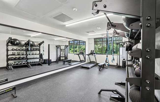 A well-equipped gym with various exercise machines and weights at Link Apartments® CYKEL Apartments, North Carolina, 28208
