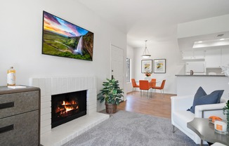 a living room with a fireplace and a dining room in the background