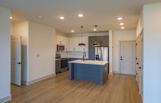 an empty kitchen with a blue island in the middle