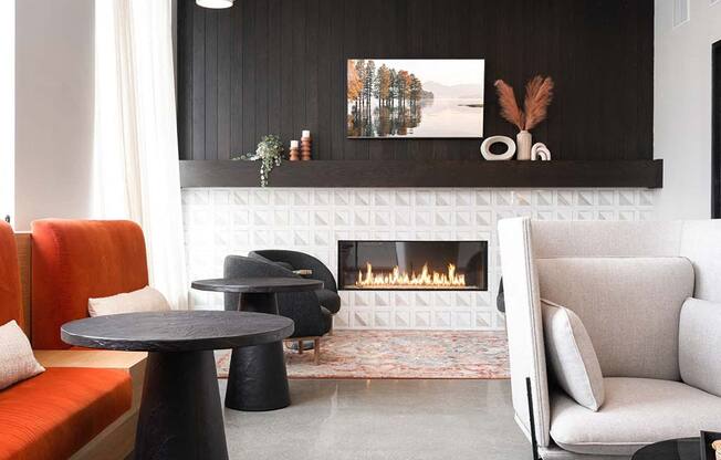 A modern living room with a fireplace and a painting on the wall.