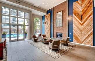 a lobby with a fireplace and chairs and a rug