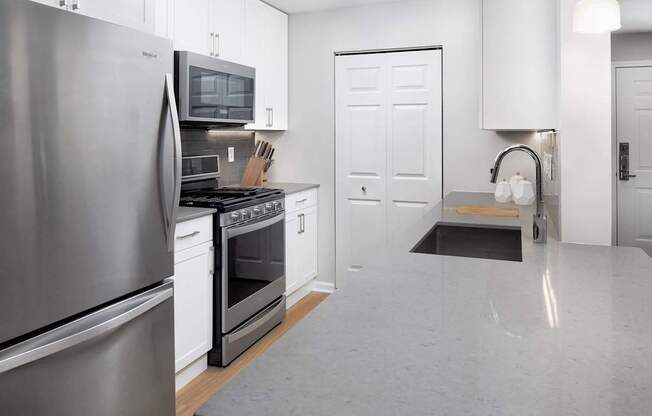 a kitchen with stainless steel appliances and white cabinets