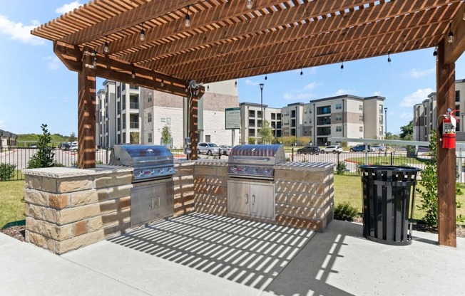 A wooden pergola with a trash can and a fire hydrant.