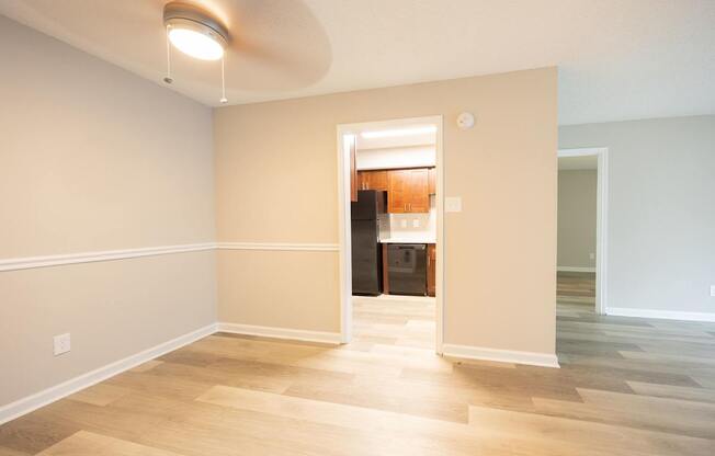 A room with a light on the ceiling and a doorway leading to another room.