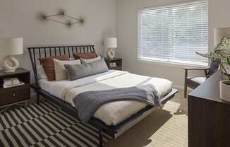 a bedroom with a bed and two windows