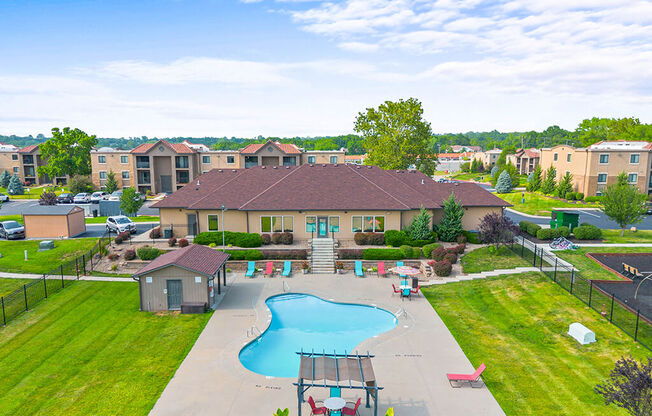 an aerial view of an outdoor swimming pool with umbrellas and tables and chairs